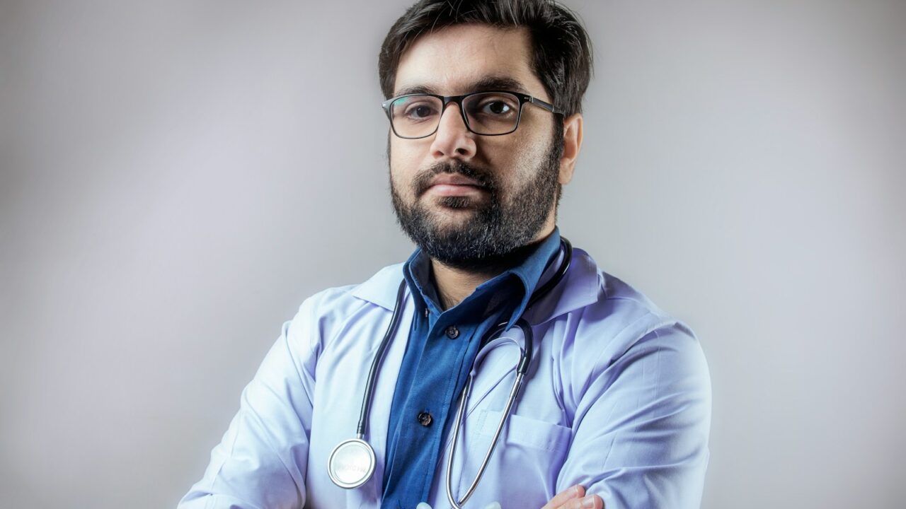 homme en chemise violette portant des lunettes à monture noire
