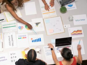 Vue de dessus d'une équipe collaborant sur des documents de stratégie et d'analyse marketing.