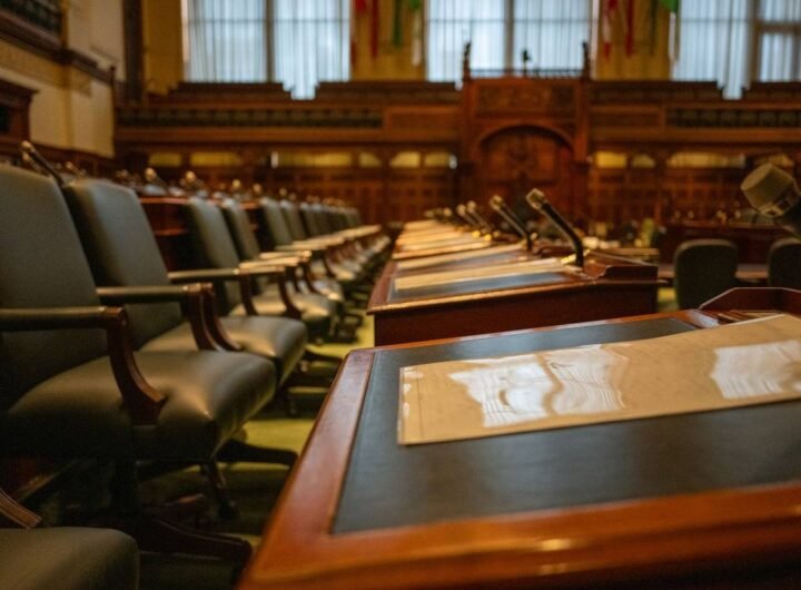 Salle de réunion avec des bureaux en bois, des chaises en cuir et des microphones