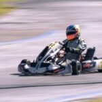 Un pilote en kart de course sur circuit, vitesse ressentie
