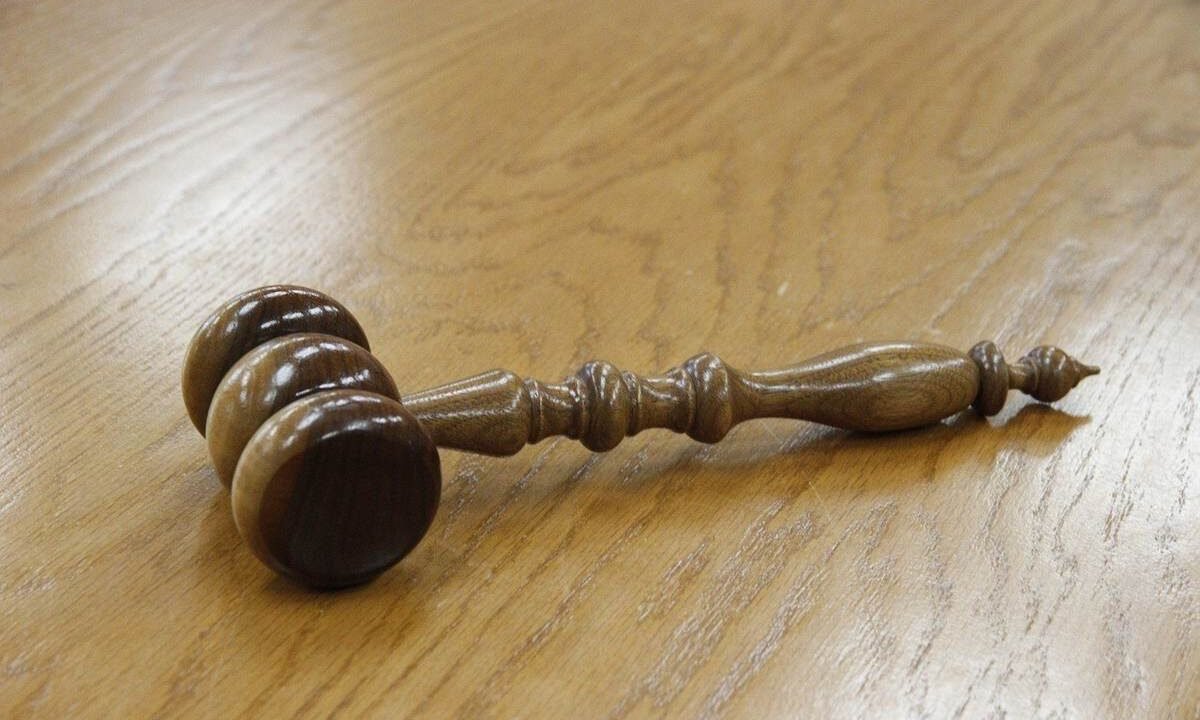 Marteau en bois avec trois poids sphériques sur une table en bois
